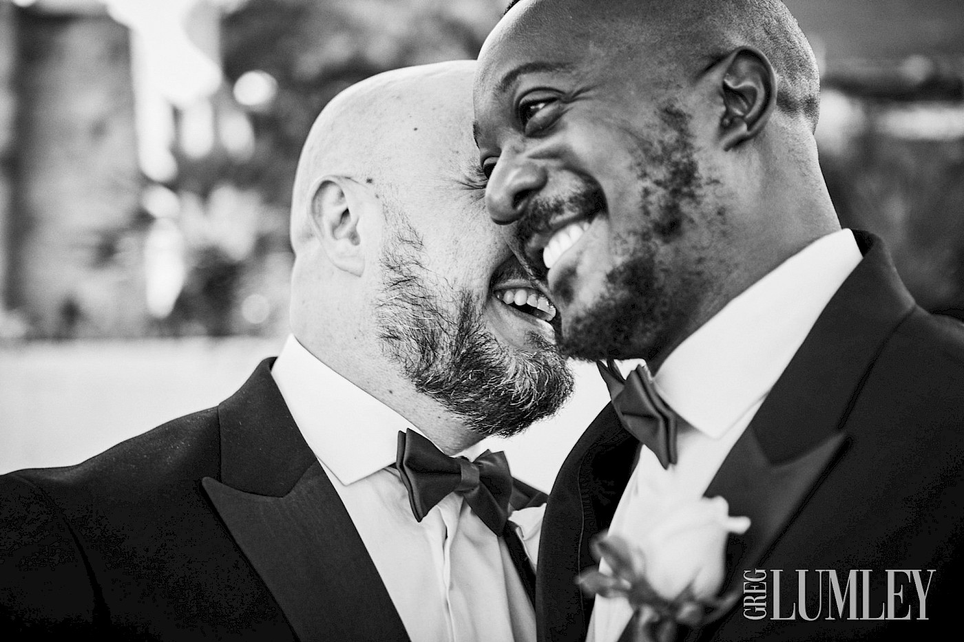 Gay interracial couple share a moment of laughter on their wedding day